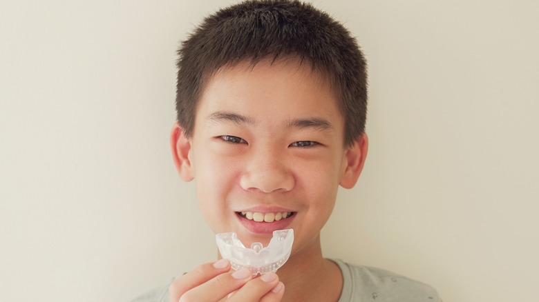 Boy holding mouth guard
