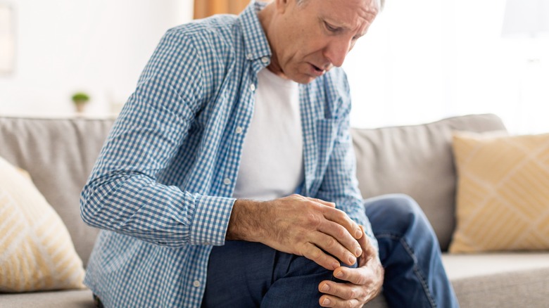 Older man rubbing knee