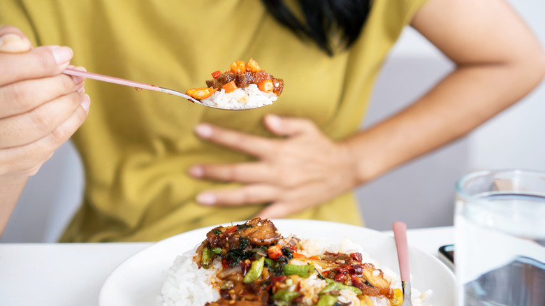 Woman with stomach pain while eating