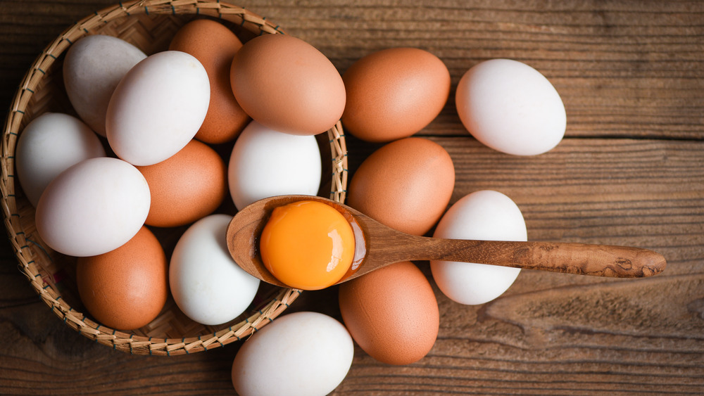 Duck eggs and chicken eggs in a basket with egg yolk