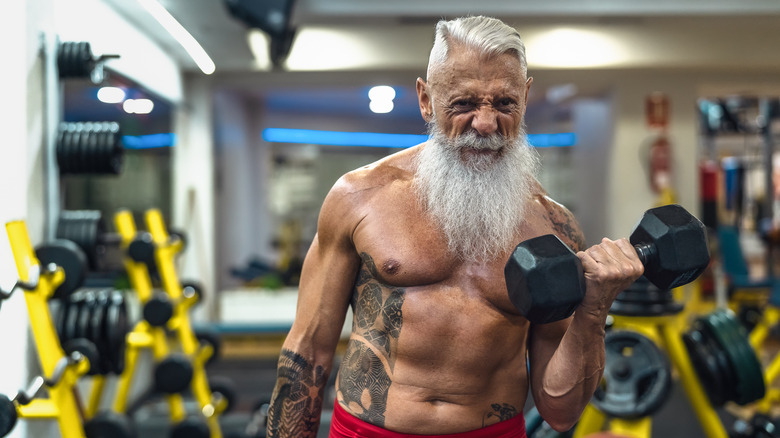 A man does bicep curls in the gym