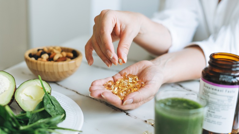 Woman holding omega-3 supplements