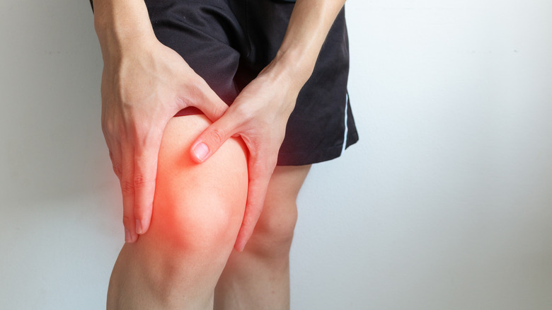 hands holding inflamed knee