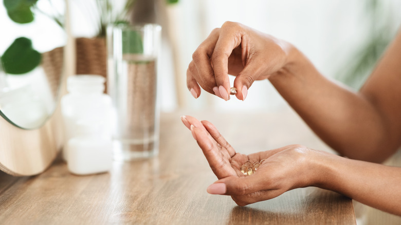 Women holding supplements in her hand.