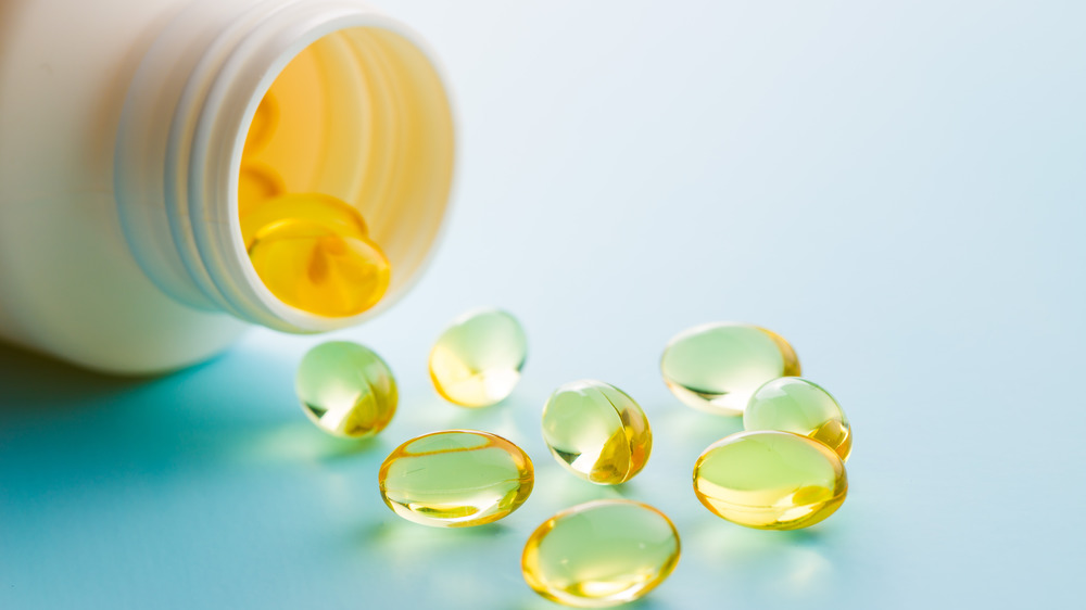 Clear yellow pills spilling out of a bottle