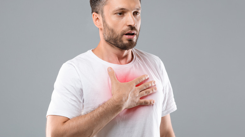 Man holding hand over glowing chest