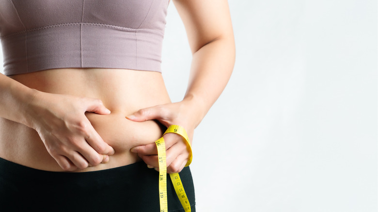 Woman pinching stomach fat