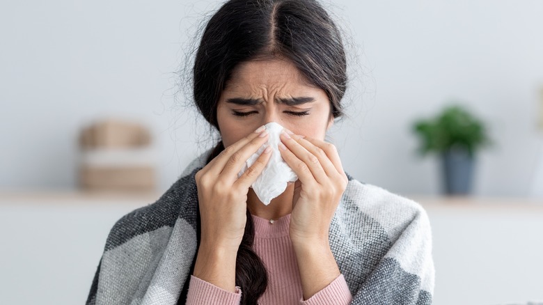 Woman with cold blowing nose