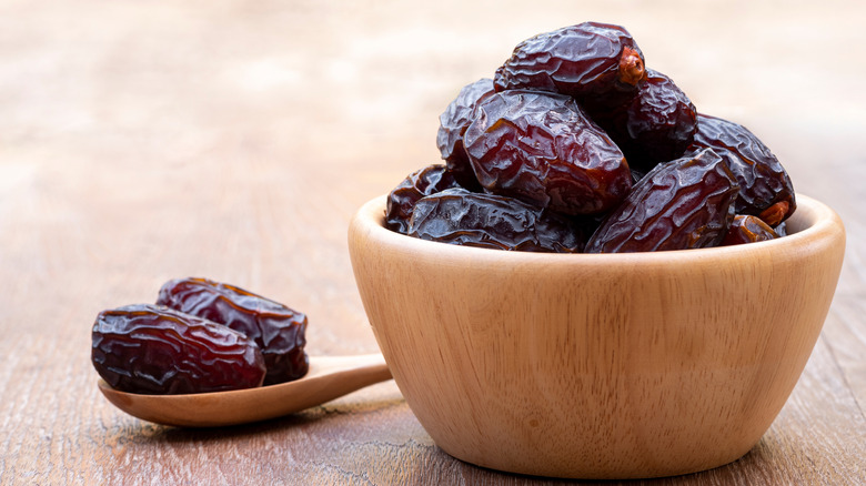 A wooden bowl full of dates