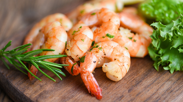 Grilled shrimp on a brown cutting board