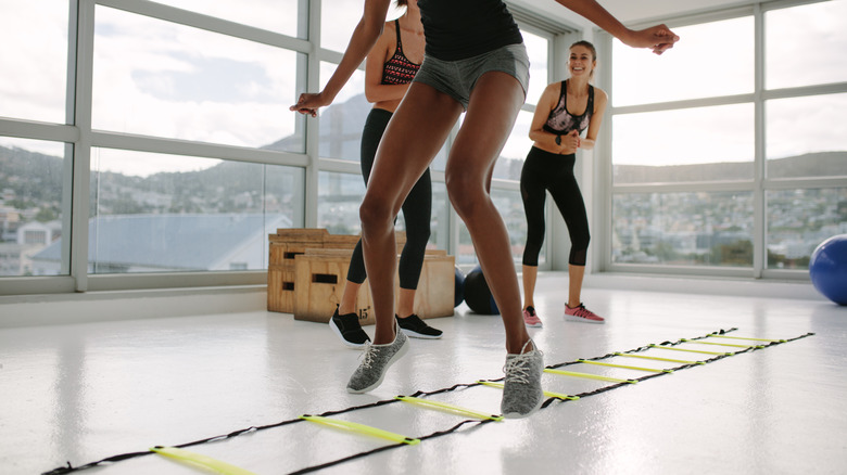 A young woman using an agility ladder 