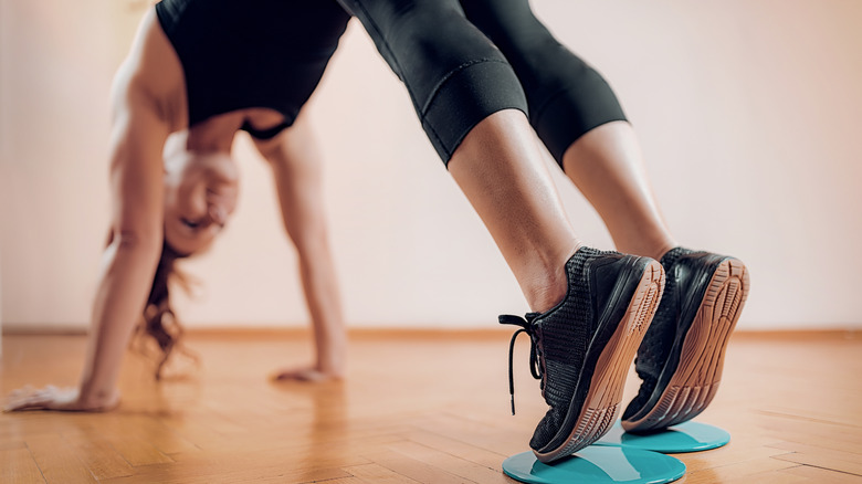 A woman exercising with sliding discs