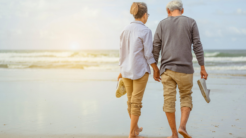 Senior couple holding hands walking
