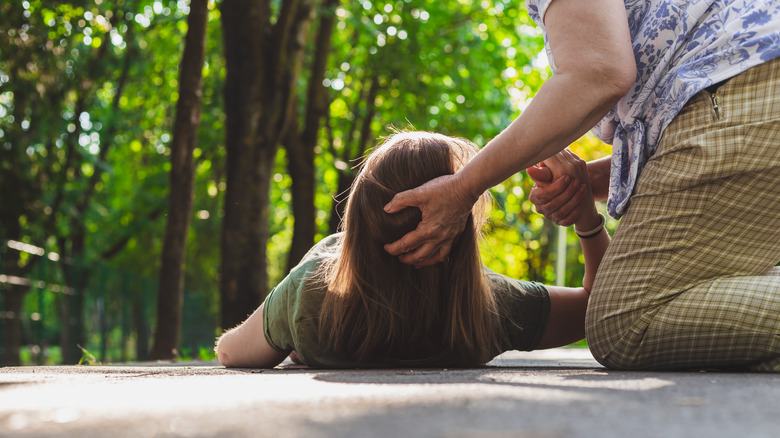 Woman helping a girl who fainted