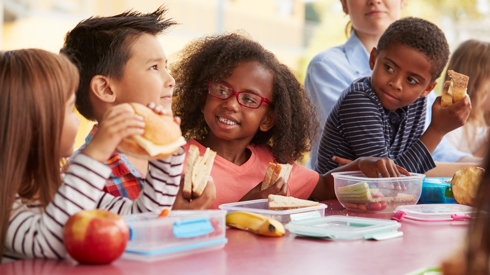 Kids eating lunch together at lunch table