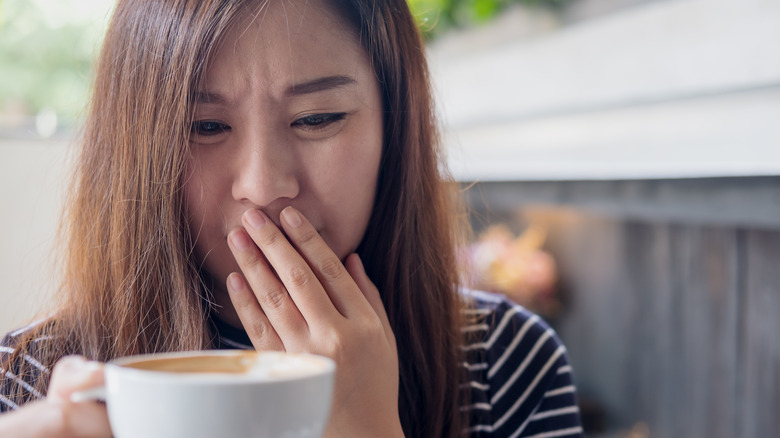 Woman staring intently at cappuccino