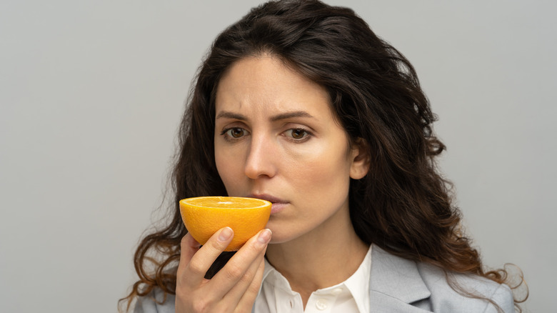 woman trying to smell an orange