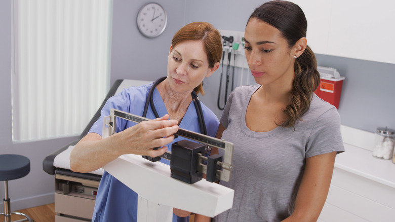 doctor weighing woman