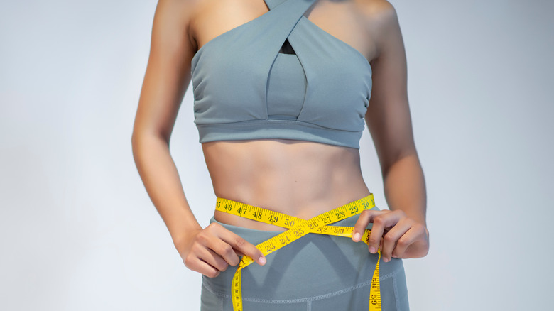 Close-up of a woman measuring her waist after exercise