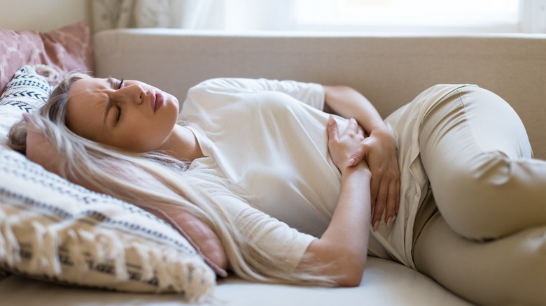 Woman suffering from stomach pain laying down