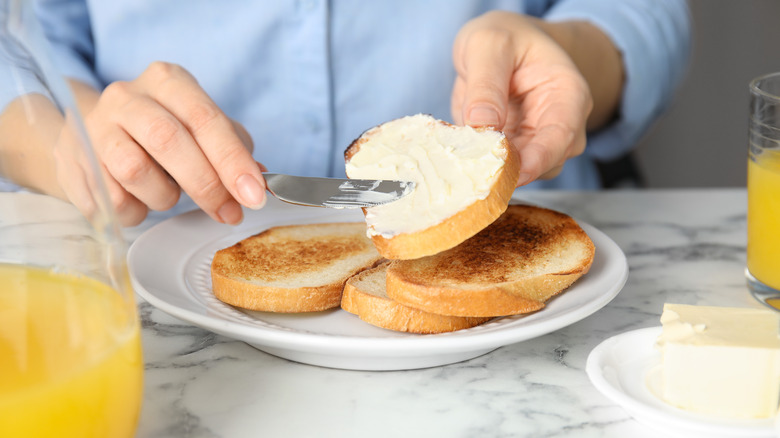 woman spreading margarine on toast