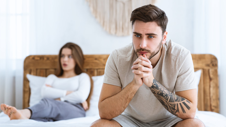 man sitting on edge of bed