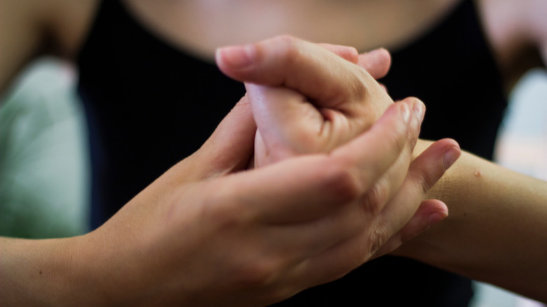 Closeup hands clasped to crack knuckles