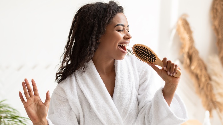 woman singing into hairbrush