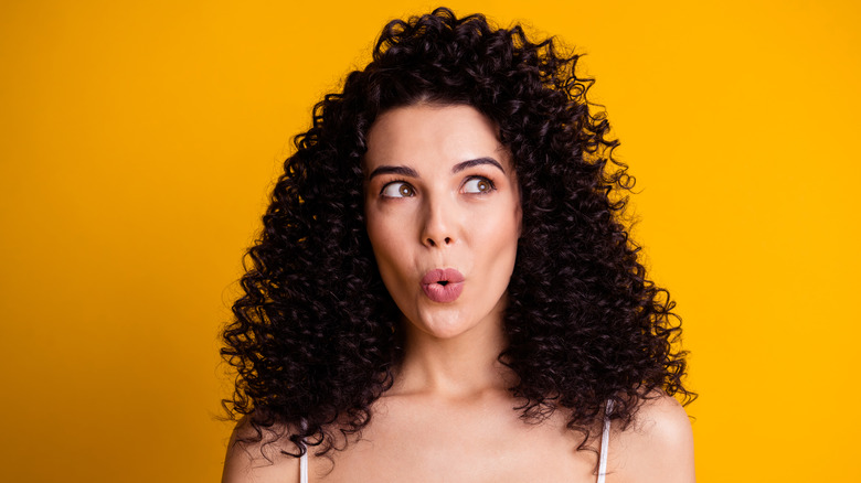 Woman trying to whistle on a orange background