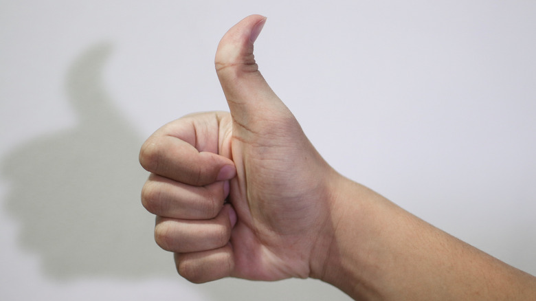 A hand making thumbs-up gesture