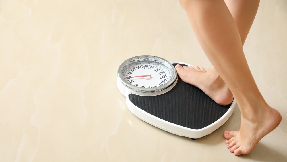 woman stepping on a scale