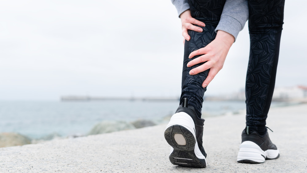 runner holding calf with cramp