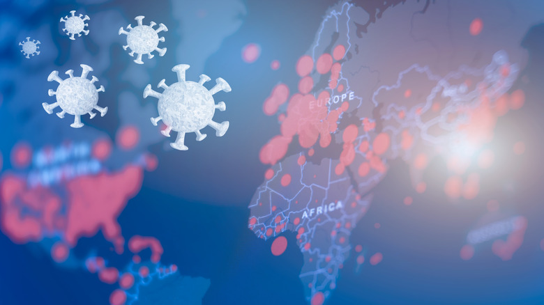 A world map overlaid with the COVID-19 virus