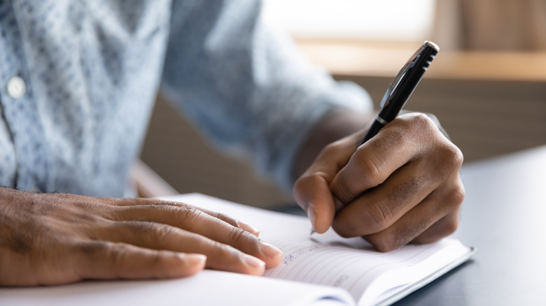 Person writing with left hand
