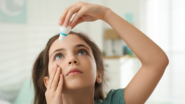 Girl putting in eye drops 