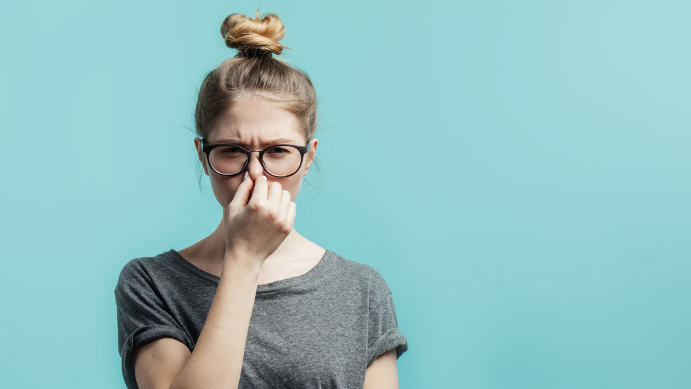 Woman holding nose