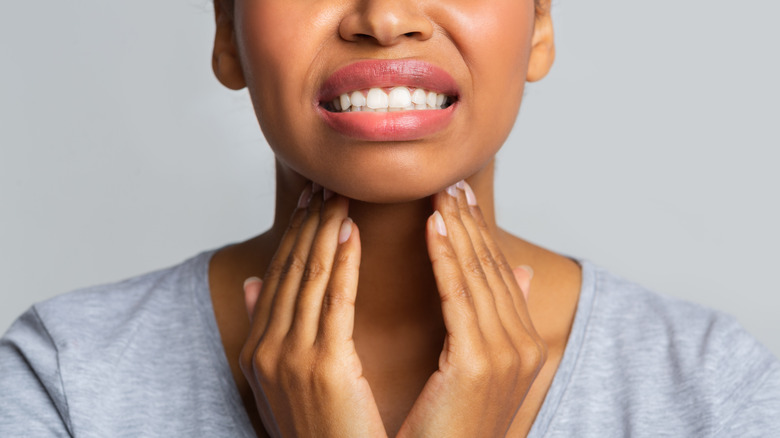 Woman touching her throat