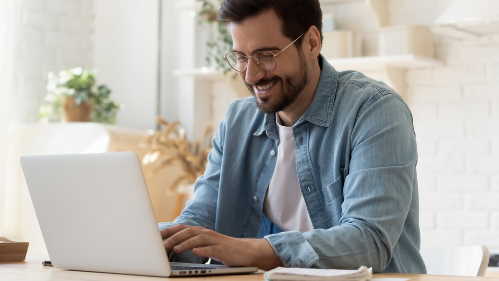 Man in glasses typing on computer