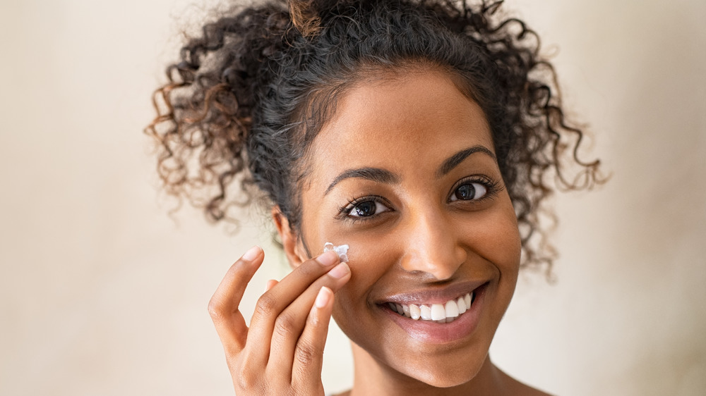 woman applying moisturizer