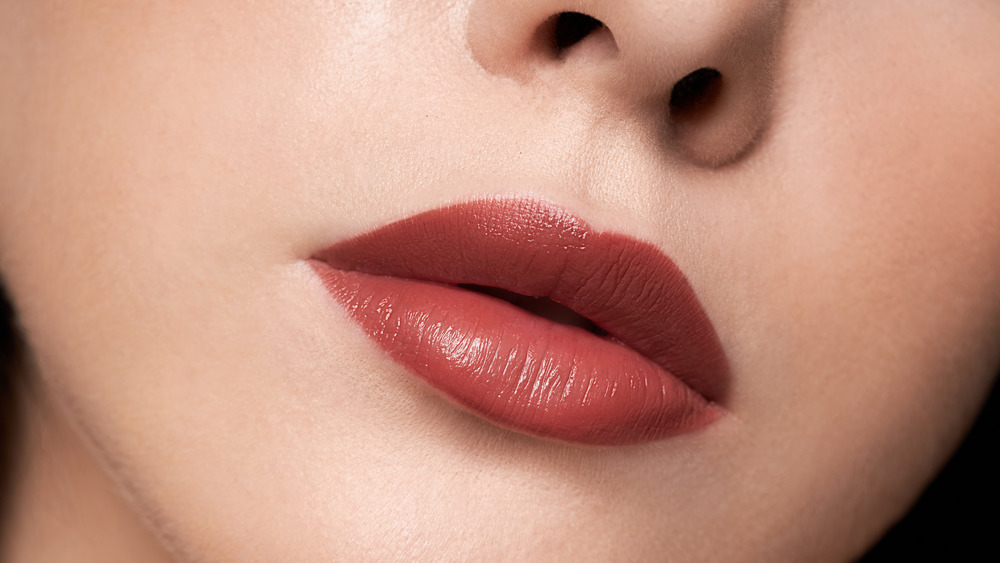 Close up of a woman with lipstick defining her cupid's bow 