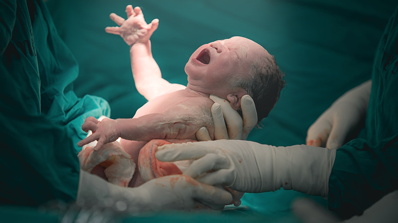 Newborn baby being held
