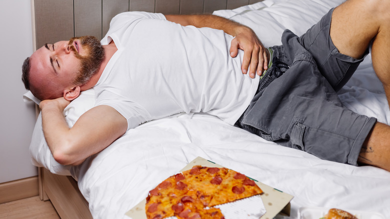 Man tired after eating pizza