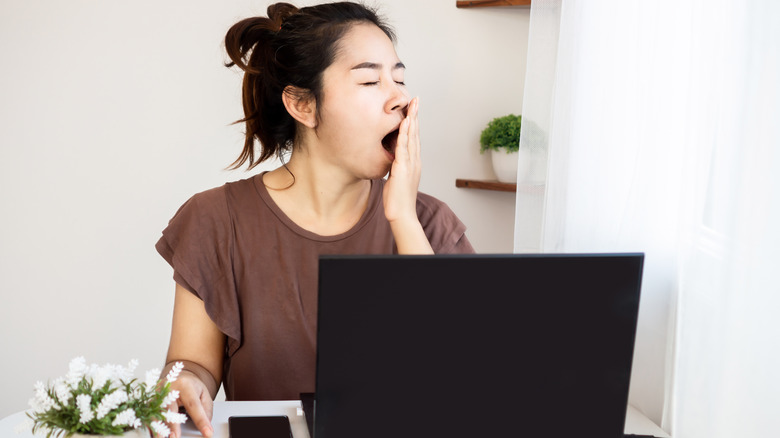 woman yawning at her desk