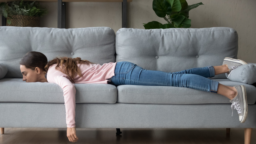 girl lying rest at home in living room buried her face in couch feels exhaustion