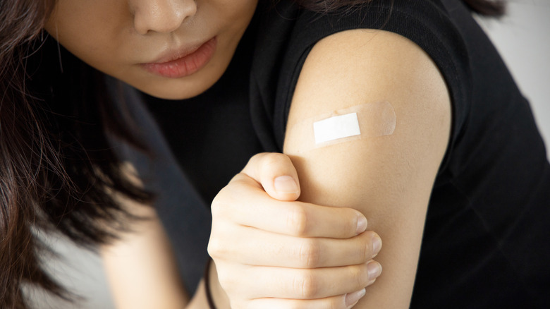 young woman looking pained after receiving the flu shot 