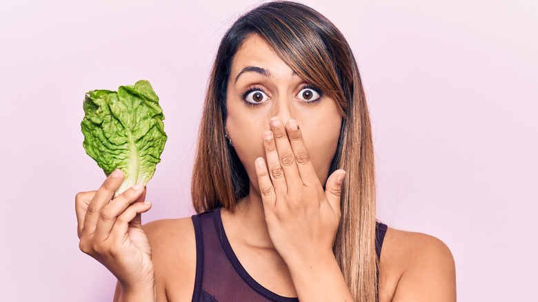 woman holding lettuce leaf