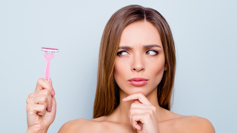 young woman contemplating sharing her razor 