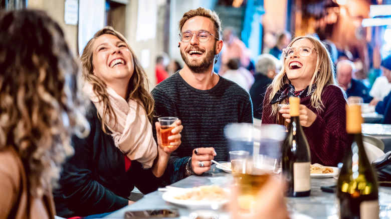 Friends laughing and eating at a restaurant