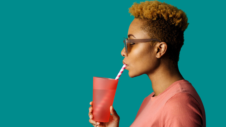 person drinking from straw in cup