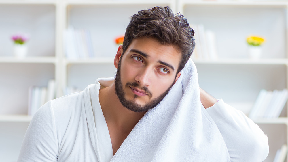 young man towel-drying his hair 